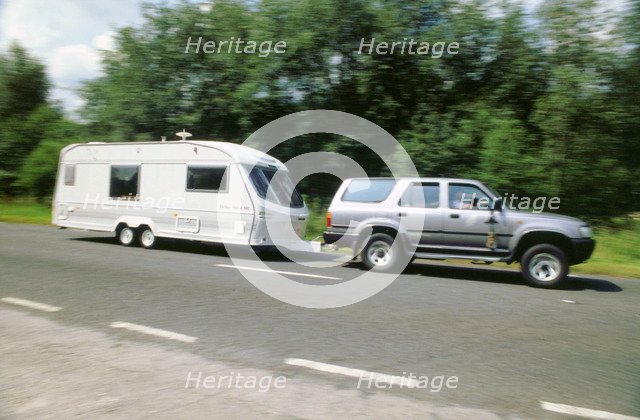 1995 Toyota Landcruiser towing large caravan at speed. Artist: Unknown.
