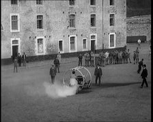 A Crashable Car With a Circular Frame Allowing It To Roll Over Being Tested in Front of..., 1926. Creator: British Pathe Ltd.