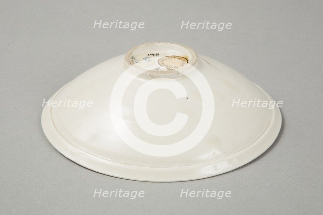 A shallow cream glazed bowl with rolled rim andraised footrim, Tang dynasty, c.800-900. Artist: Unknown.