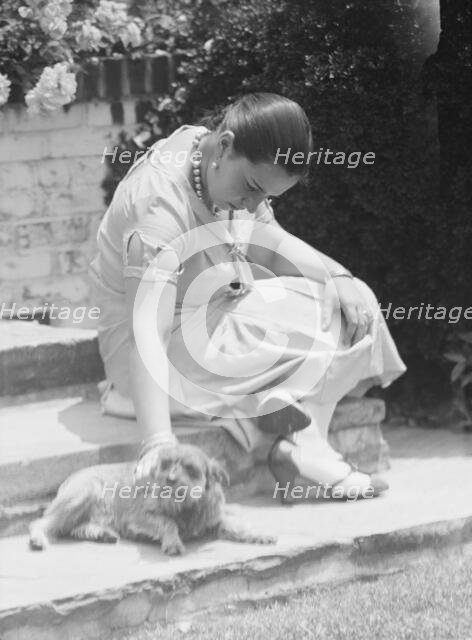 Manship, Pauline, Miss, with dog, seated outdoors, 1931 June 14. Creator: Arnold Genthe.