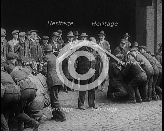 A Male Stuntman Bending Girders Over His Shoulders, 1926. Creator: British Pathe Ltd.