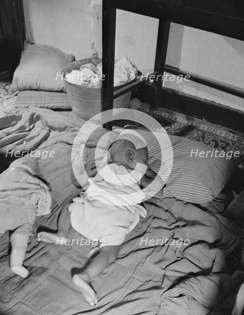 Grandchild of Mrs. Ella Watson, a government charwoman, taking her...nap, Washington, D.C., 1942. Creator: Gordon Parks.
