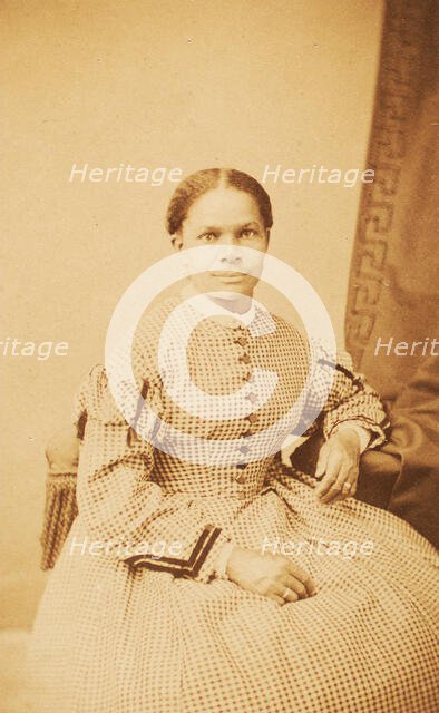 Studio portrait of unidentified seated woman wearing check dress, c1860-c1869. Creator: Decamp & Crane.