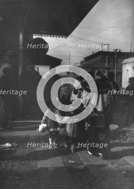 Women and children crossing a street, Chinatown, San Francisco, between 1896 and 1906. Creator: Arnold Genthe.