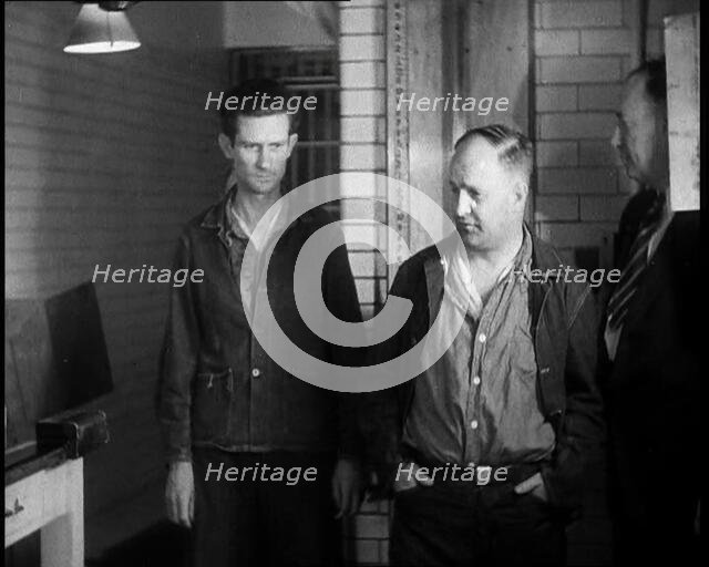 A group of Male Americans Civilians Wearing Prisoners Outfits Being Escorted Into a Room..., 1930. Creator: British Pathe Ltd.