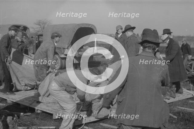 Setting up a tent in the camp for white flood refugees, Forrest City, Arkansas, 1937. Creator: Walker Evans.