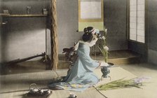 Girl arranging flowers, 1890's. Creator: Japanese Photographer (19th Century).