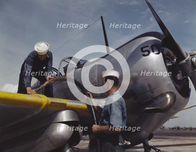 Feeding an SNC advanced training plane its essential supply of gas...Corpus Christi, Texas, 1942. Creator: Howard Hollem.