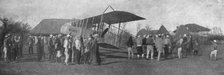 'La retraite de nos aviateurs par l'Albanie; Biplan entoure par la population masculine..., 1916. Creator: Unknown.