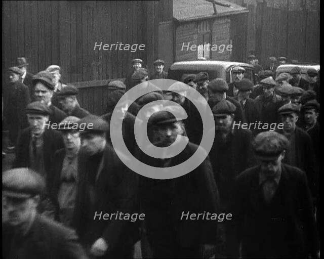 Crowd of Men Walking Through the Street Towards the Camera, 1933. Creator: British Pathe Ltd.