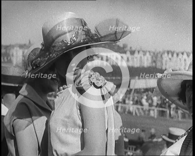 Three Female Civilians Wearing Smart Summer Outfits and Hats Chatting at the Horse Race, 1920. Creator: British Pathe Ltd.