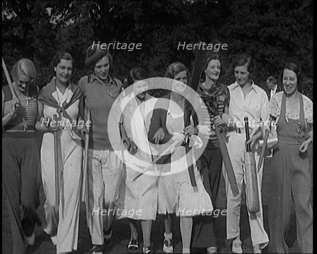 Female Civilians Carrying Cricket Bats Walking in a Line, 1920s. Creator: British Pathe Ltd.