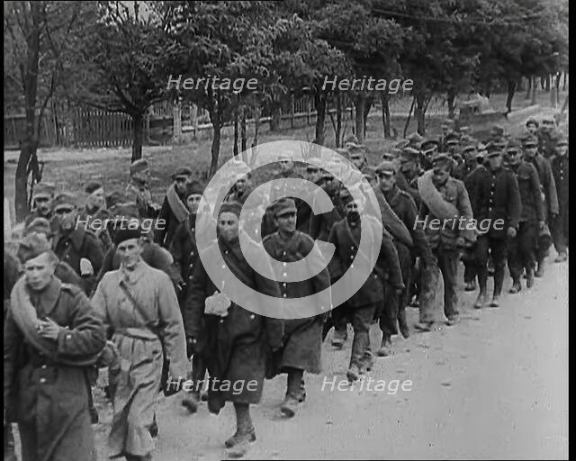 Male Polish Soldiers Walking Along an Unpaved Road Beside a Line of Trees With Fences Beyond, 1939. Creator: British Pathe Ltd.