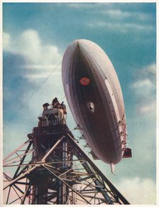 The US airship 'Macon' being moored to the mobile mast at Lakehurst, New Jersey, c1935 (c1937). Artist: Unknown.