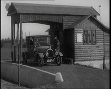 A Motorcar Driving Into the Forecourt of the First Petrol Station, 1920. Creator: British Pathe Ltd.