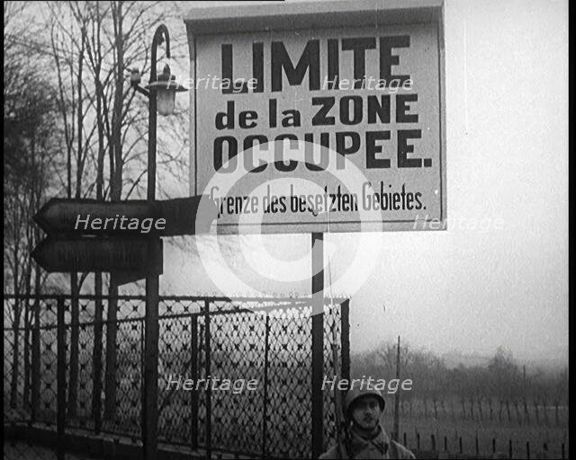 A Sign Read 'Limite de la Zone Occupee. Grenze des Besetzten Gebietes', a French Soldier..., 1924. Creator: British Pathe Ltd.