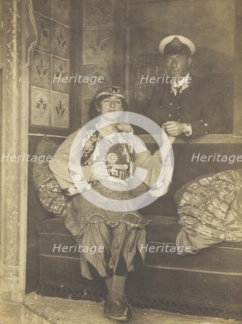 A sailor holds hands with a man in elaborate drag, [between 1910 and 1999?]. Creator: Unknown.