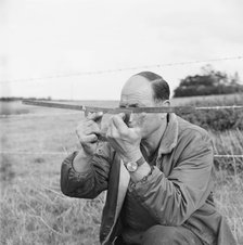 A man holding a surveyor's protractor working on the route of the Mersey oil pipeline, 24/09/1967. Creator: John Laing plc.