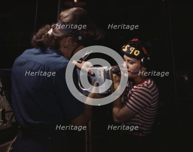 Two women employees of North American Aviation, Incorporated, assembling a section of a..., 1942. Creator: Alfred T Palmer.