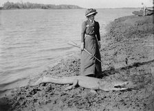Unknown lady with rifle and a saltwater crocodile, 1910. Creator: Robert Augustus Henry L'Estrange.