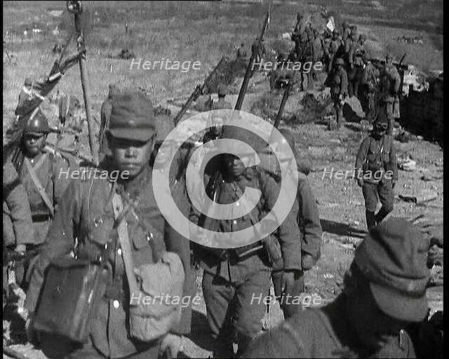 Male Japanese Soldiers With Rifles Walking up a Hillside, Near the City of Hankow, 1937.  Creator: British Pathe Ltd.
