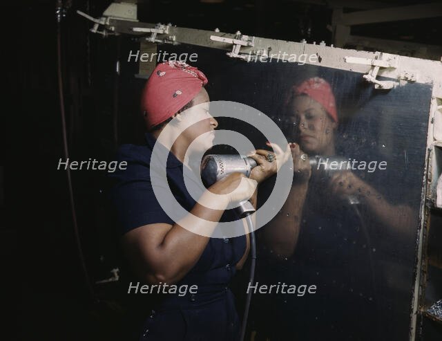 Operating a hand drill at Vultee-Nashville...working on a "Vengeance" dive bomber, Tennessee, 1943. Creator: Alfred T Palmer.