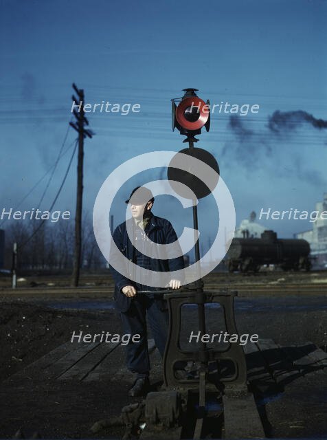 Daniel Senise throwing a switch while at work in an Indiana Harbor Belt Line railroad yard, 1943. Creator: Jack Delano.
