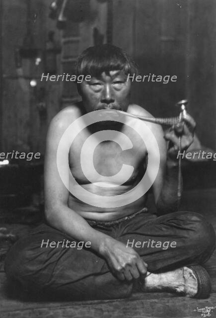 Eskimo smoking pipe, between c1900 and 1927. Creator: Lomen Brothers.