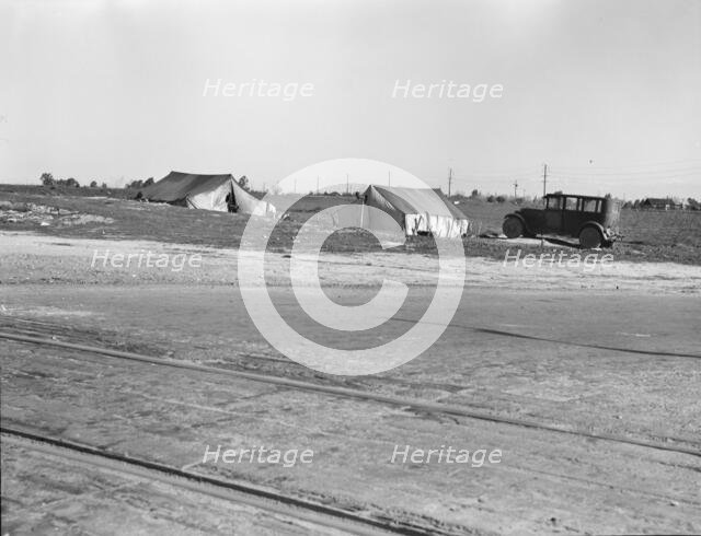 Migrants' tents...along the right of way of the southern pacific, near Fresno, California, 1939. Creator: Dorothea Lange.