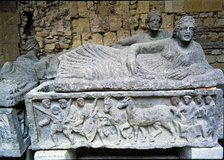 Etruscan stone sarcophagus with reliefs of Eastern influence, with a sculpture of a woman lying o…