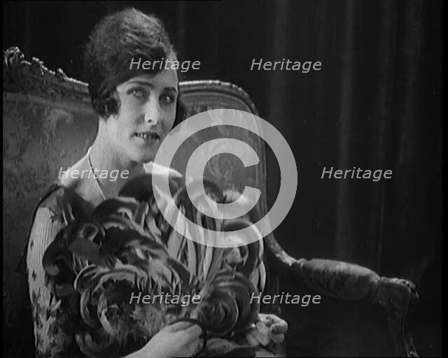 Female Civilian Using a Fan Made of Feathers, 1920. Creator: British Pathe Ltd.