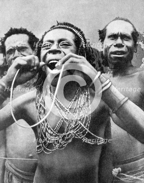 Swallowing canes in a ceremonial ritual, New Guinea, 1936.Artist: Wide World Photos