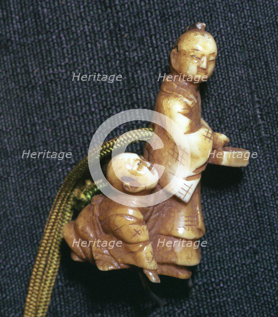 Japanese Netsuke of a man and boy at new year, 19th century. Artist: Unknown