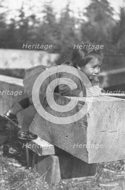 Eskimo child leaning on block of wood, 1905. Creator: Unknown.