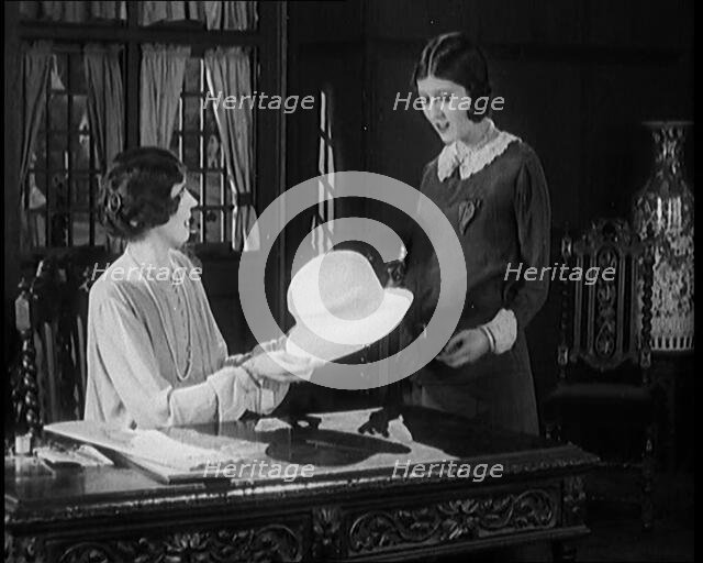 Two Female Civilians in a Drawing Room Having a Conversation About a Hat One of Them Is Holding,1920 Creator: British Pathe Ltd.