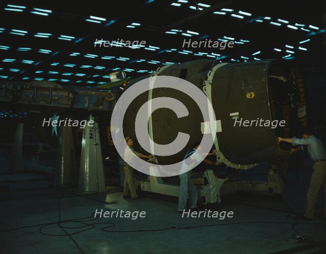 Putting the nose section of a mighty transport...Consolidated Aircraft..., Fort Worth, Texas, 1942. Creator: Howard Hollem.