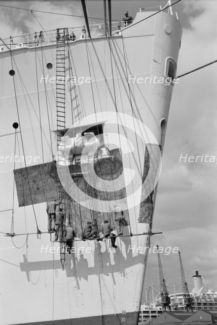Workmen repairing the bow of a ship in London docks, c1945-c1965. Artist: SW Rawlings