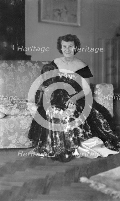 Portrait of seated woman in evening dress with her dog, c1935.  Creator: Kirk & Sons of Cowes.