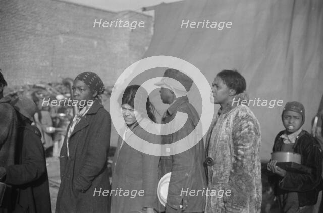 Negroes at mealtime in the flood refugee camp, Forrest City, Arkansas, 1937. Creator: Walker Evans.