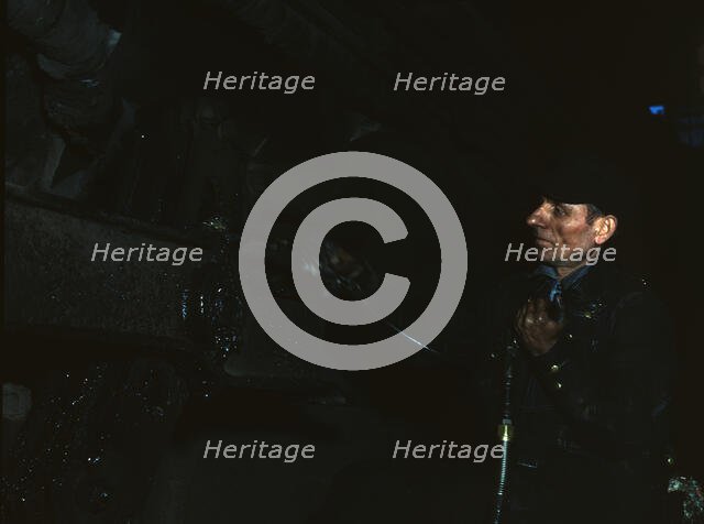 Greasing a locomotive at the 40th Street shops of the C & NW RR, 1942. Creator: Jack Delano.