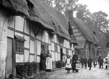 Women and children posing outside a thatched cottage, Ramsbury, Wiltshire, c1860-c1922. Artist: Henry Taunt