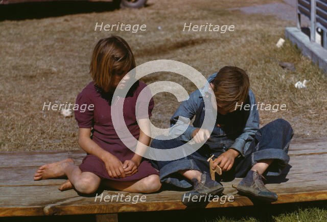 Boy building a model airplane as girl watches, FSA ... camp, Robstown, Tex., 1942. Creator: Arthur Rothstein.