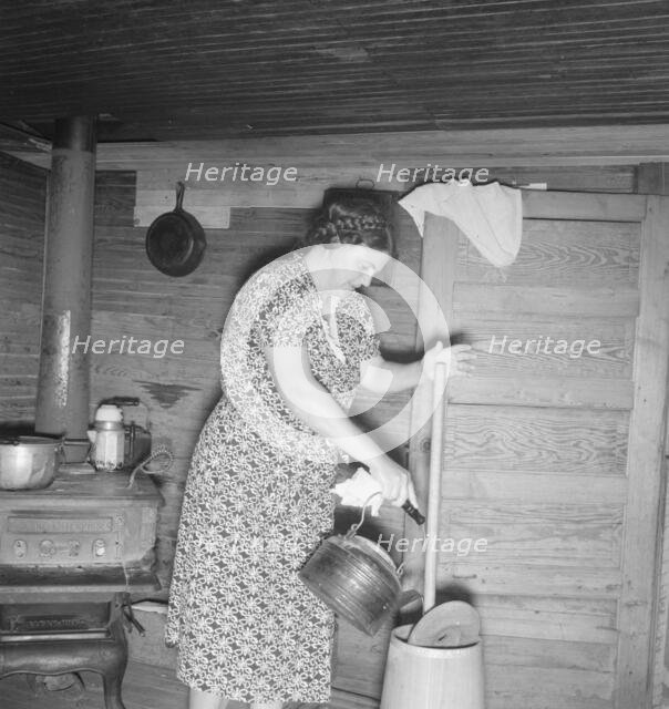 Wife of tobacco sharecropper cleaning butter churn, Person County, North Carolina, 1939. Creator: Dorothea Lange.