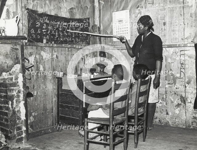 Negro mother teaching children numbers and alphabet in home of sharecropper..., Jan 1939. Creators: Farm Security Administration, Russell Lee.