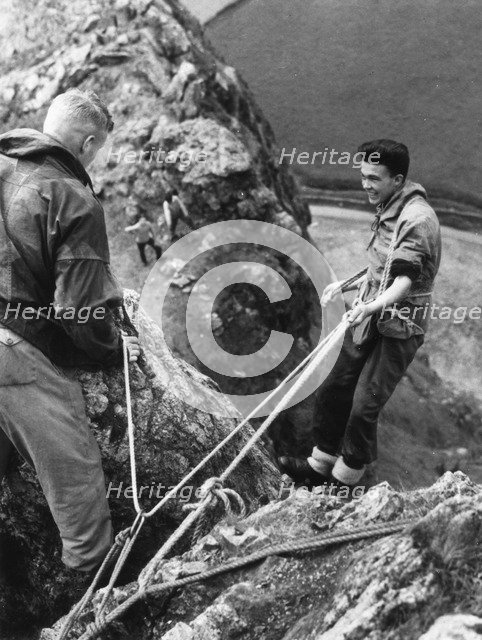 Boy about to start descent of rock face, Outward Bound School, Eskdale, Cumbria,1950. Artist: Unknown