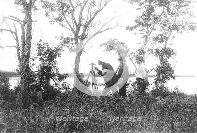 Prospectors conducting a triangulation survey from the bank of the Zeya River, 1909. Creator: Unknown.