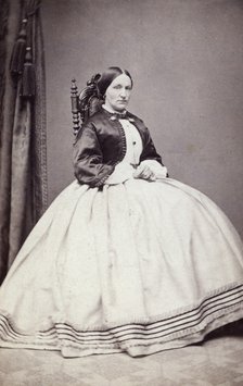 Studio portrait of a young woman in an ankle-length dress, late 19th century(?). Artist: Unknown