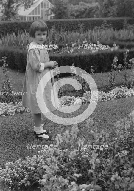 Truesdale, Virginia, Miss, standing in a garden, 1915 July 21. Creator: Arnold Genthe.