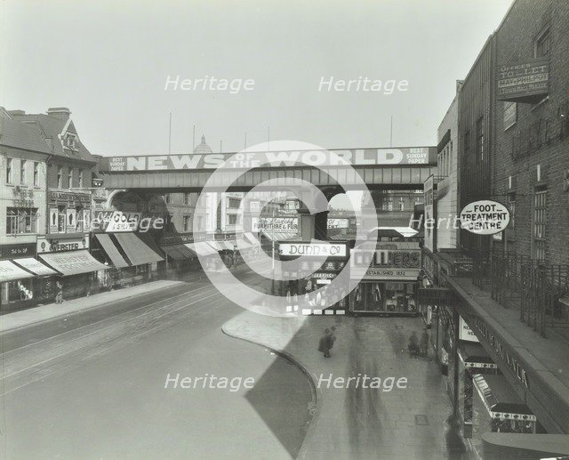 Railway bridge and advertising over the Brixton Road, Lambeth, London, 1938. Artist: Unknown.