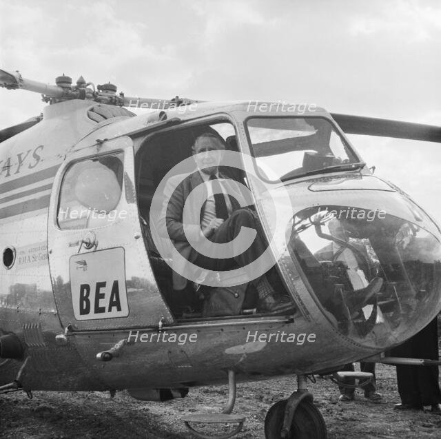 Artist Terence Cuneo in a BEA helicopter, London to Yorkshire Motorway, 10/1958. Creator: John Laing plc.